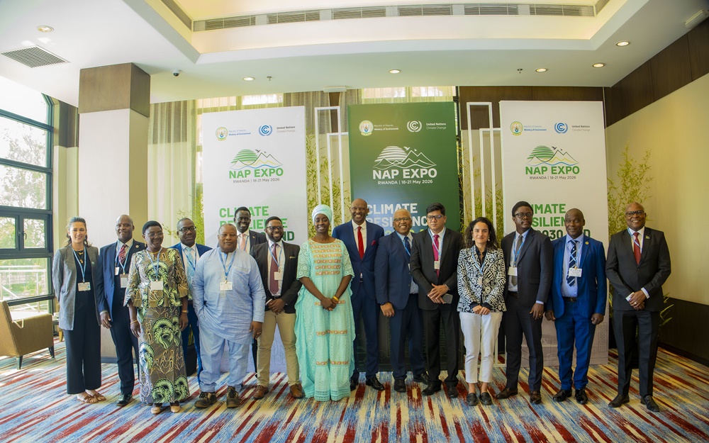 Group of professionals in business attire posing for a photo at a conference with NAP Expo banners in the background, indoors at a pavilion-like venue.