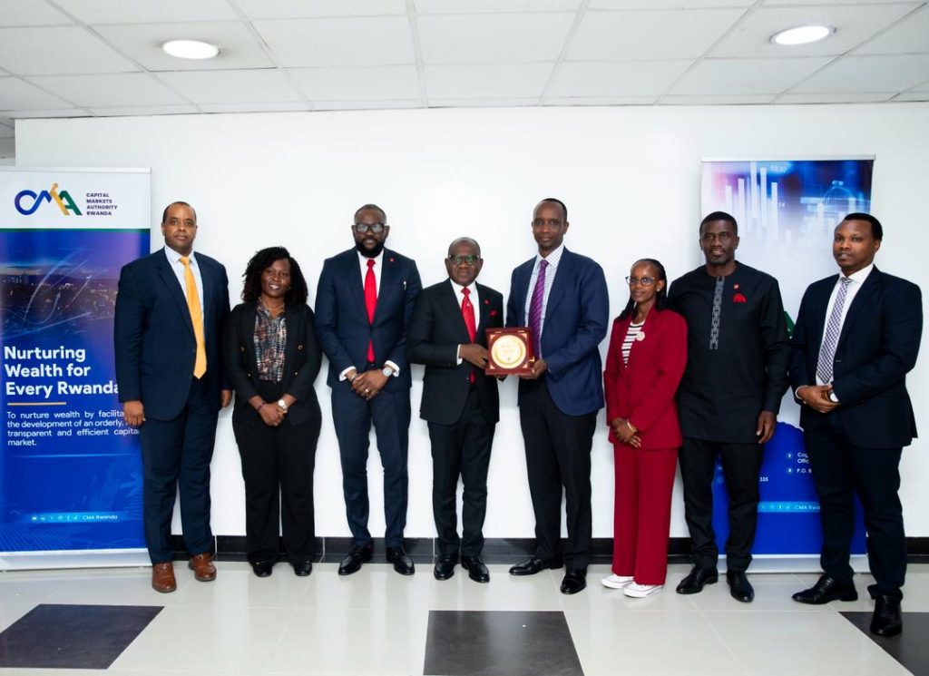 Eight professionals in business attire pose with a central award plaque in a corporate setting, CMA banners on both sides.