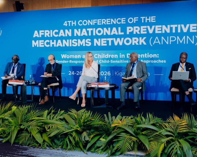 Panel of five speakers seated on stage at a blue conference backdrop, discussing Women and Children in detention (ANPMN conference).