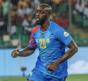 Soccer player in blue jersey with number 20 sprinting on the field during a match, stadium in background