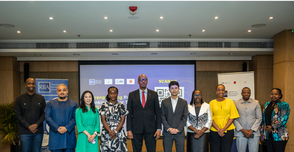 Group of ten diverse professionals posing for a group photo at a conference or workshop, with banners and a presentation screen behind them.