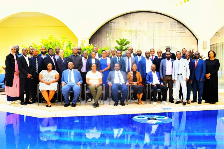 Group of professionally dressed people posing for a photo by a pool in an outdoor courtyard.